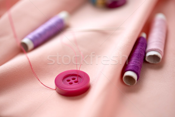 sewing buttons, spools of thread and cloth Stock photo © dolgachov