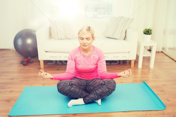 happy woman stretching leg on mat at home Stock photo © dolgachov