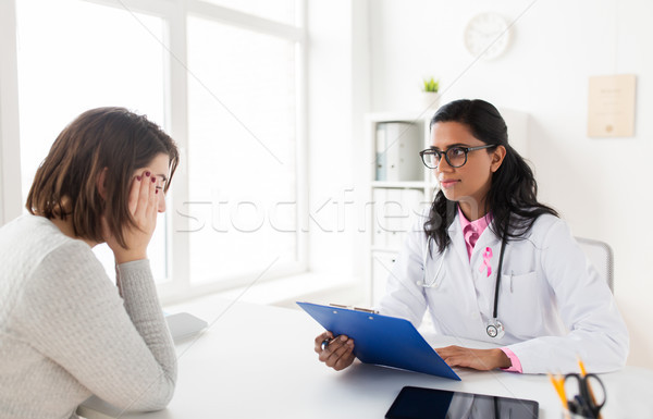 doctor with pink awareness ribbon and sad patient Stock photo © dolgachov