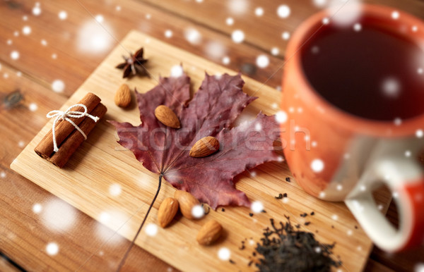 cup of tea, maple leaf and almond on wooden board Stock photo © dolgachov