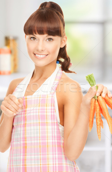Stock photo: housewife with carrots at the kitchen