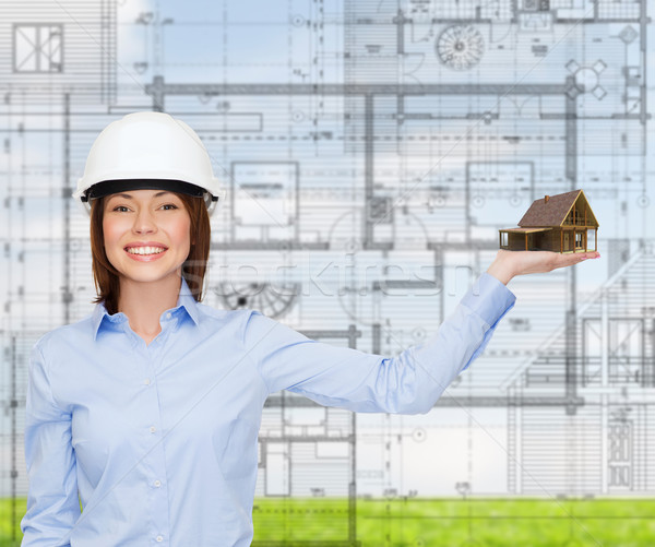 businesswoman in helmet holding house on palm Stock photo © dolgachov