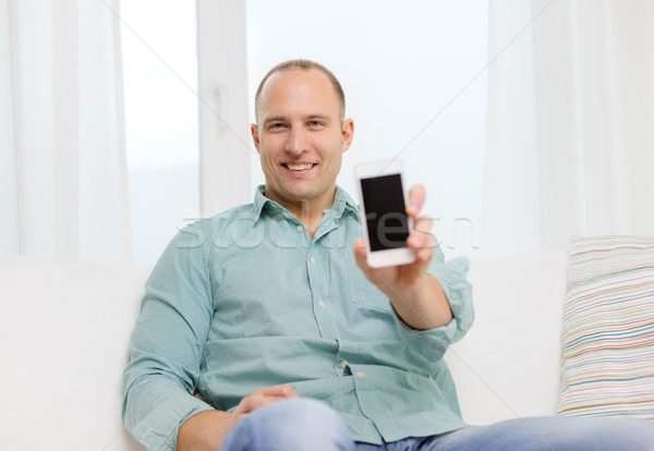 smiling man with smartphone at home Stock photo © dolgachov