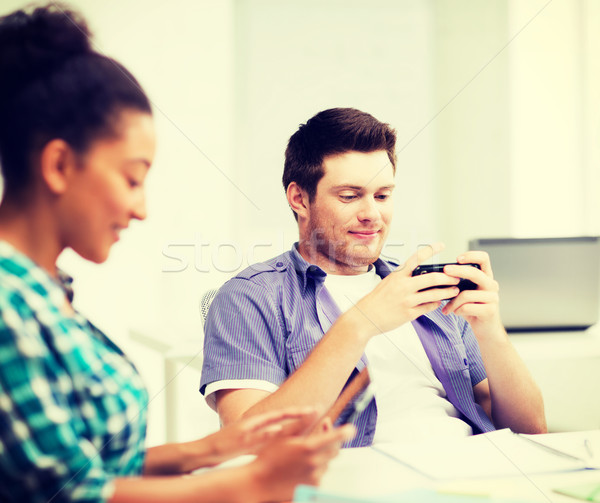 Foto d'archivio: Studenti · guardando · scuola · istruzione · telefoni