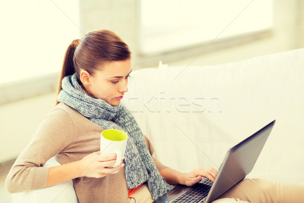 diseased woman in scarf using laptop at home Stock photo © dolgachov