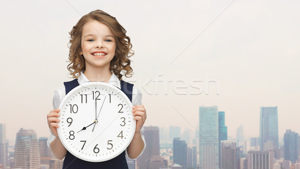 smiling girl holding big clock Stock photo © dolgachov