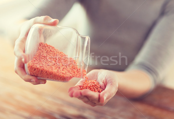 close up of female emptying jar with red lentils Stock photo © dolgachov