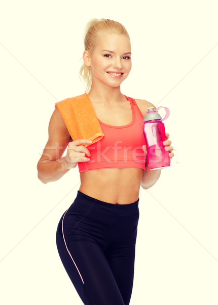 Sorridente mulher garrafa de água toalha esportes Foto stock © dolgachov
