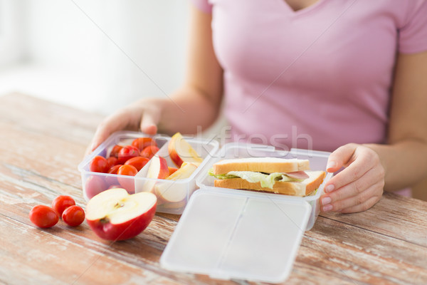 close up of woman with food in plastic container Stock photo © dolgachov