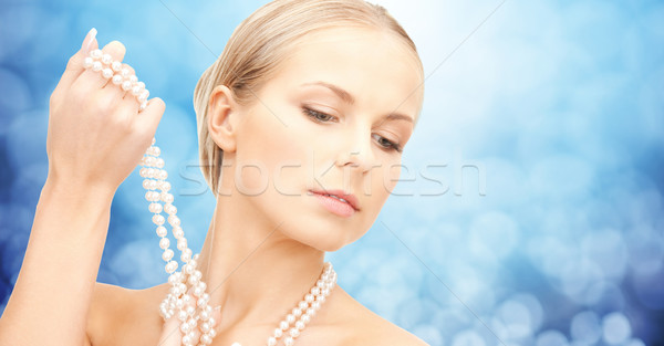 beautiful woman with sea pearl necklace over blue Stock photo © dolgachov