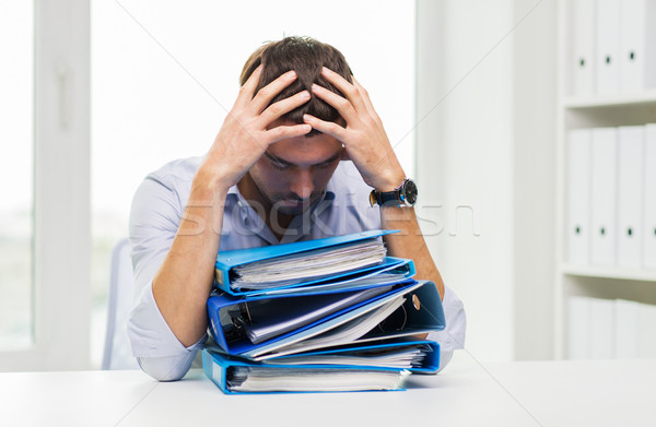 sad businessman with stack of folders at office Stock photo © dolgachov