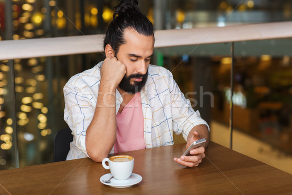 man with smartphone and coffee at restaurant Stock photo © dolgachov