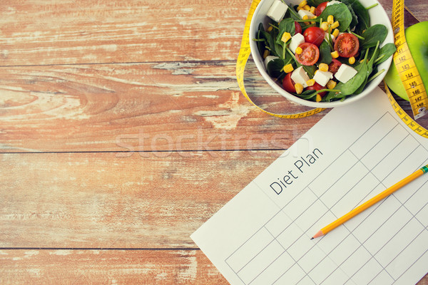 close up of diet plan and food on table Stock photo © dolgachov