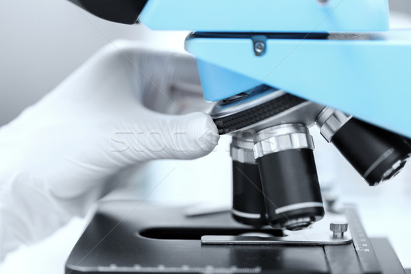 close up of scientist hand setting microscope Stock photo © dolgachov