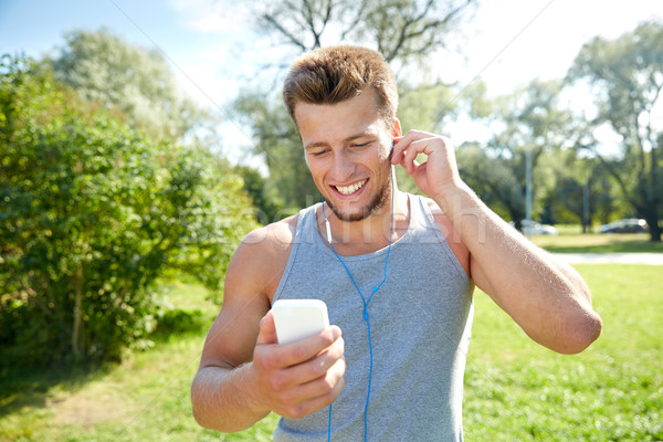Boldog férfi fülhallgató okostelefon park fitnessz Stock fotó © dolgachov