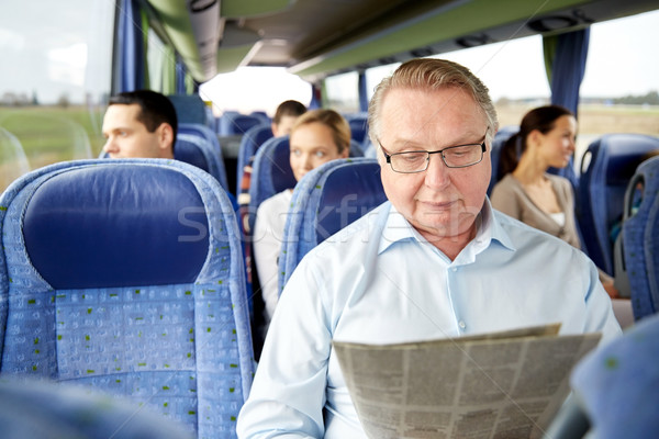 happy senior man reading newspaper in travel bus Stock photo © dolgachov