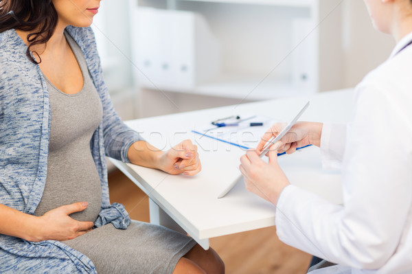 close up of doctor with tablet and pregnant woman Stock photo © dolgachov