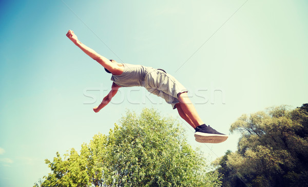 sporty young man jumping in summer park Stock photo © dolgachov