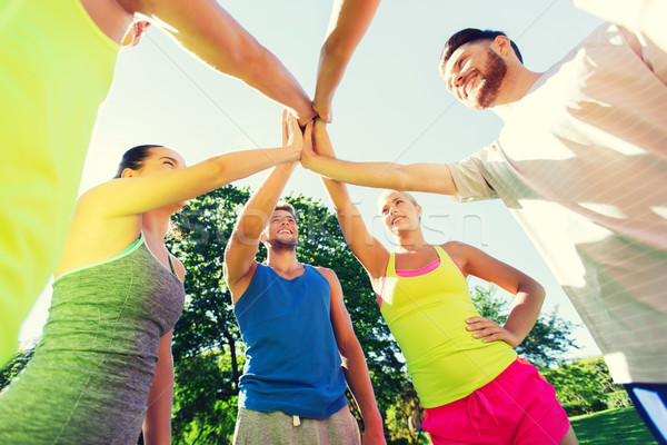 group of happy friends making high five outdoors Stock photo © dolgachov