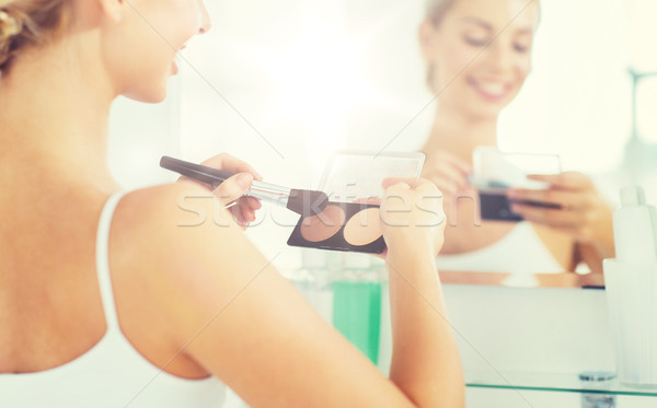 woman with makeup brush and foundation at bathroom Stock photo © dolgachov