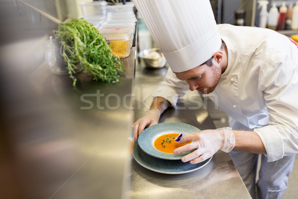 male chef decorating dish with pansy flower Stock photo © dolgachov