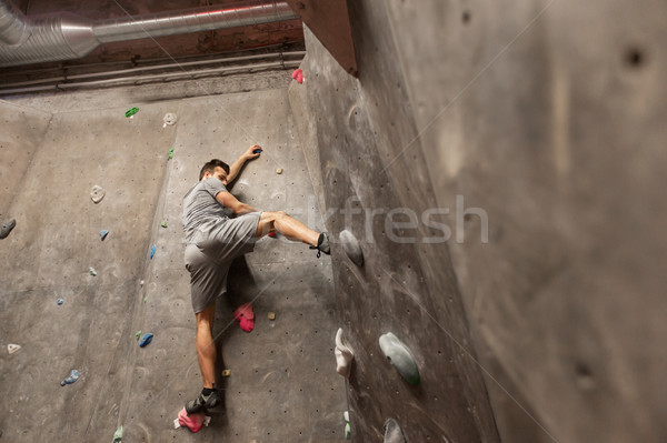 young man exercising at indoor climbing gym wall Stock photo © dolgachov