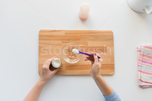 hands with spoon and jar making baby cereal Stock photo © dolgachov