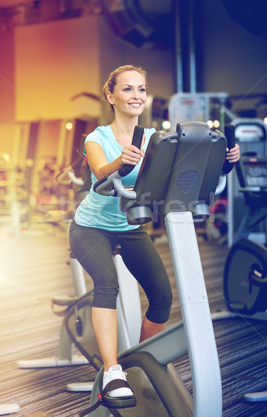 Femme souriante exercice vélo gymnase sport [[stock_photo]] © dolgachov