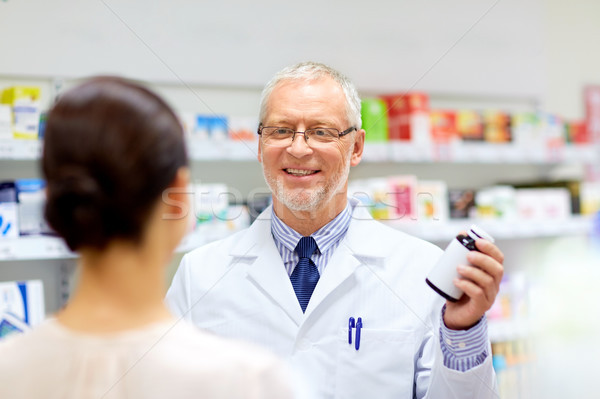 apothecary and woman with drug at pharmacy Stock photo © dolgachov