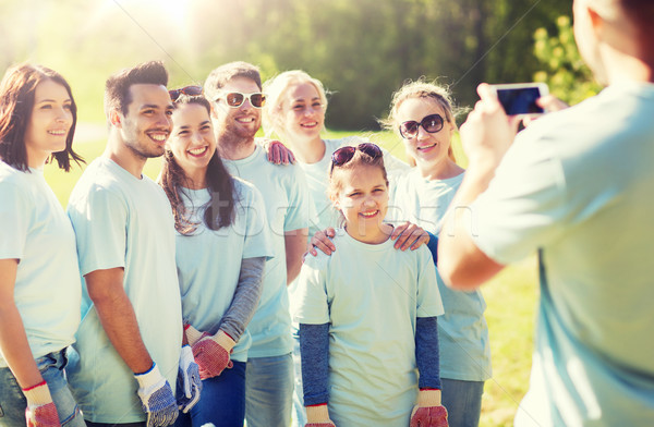 group of volunteers taking picture by smartphone Stock photo © dolgachov