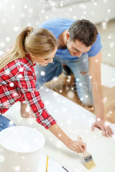 smiling couple smearing wallpaper with glue Stock photo © dolgachov