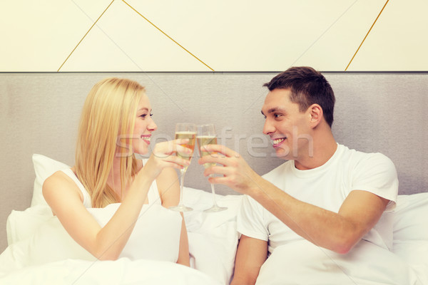 Sorridere Coppia champagne occhiali letto hotel Foto d'archivio © dolgachov