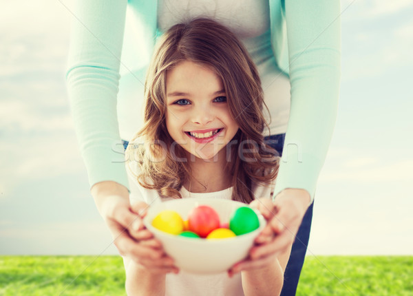 smiling girl and mother holding colored eggs Stock photo © dolgachov