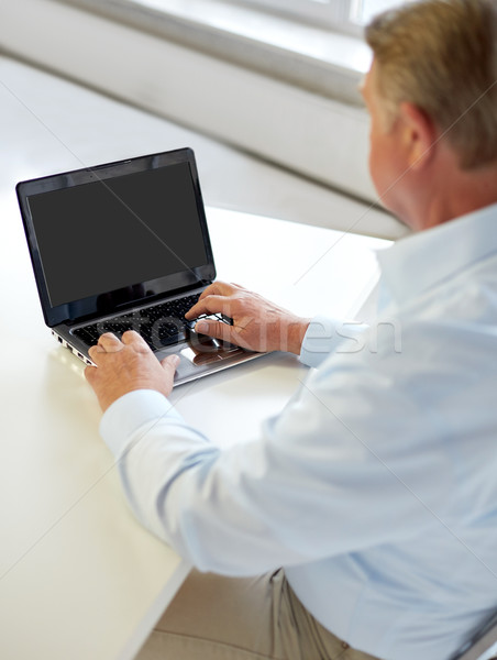 close up of senior man with laptop typing Stock photo © dolgachov