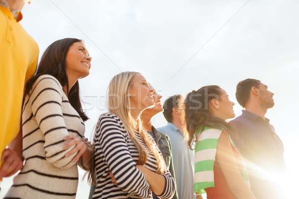 group of happy friends looking up on beach Stock photo © dolgachov