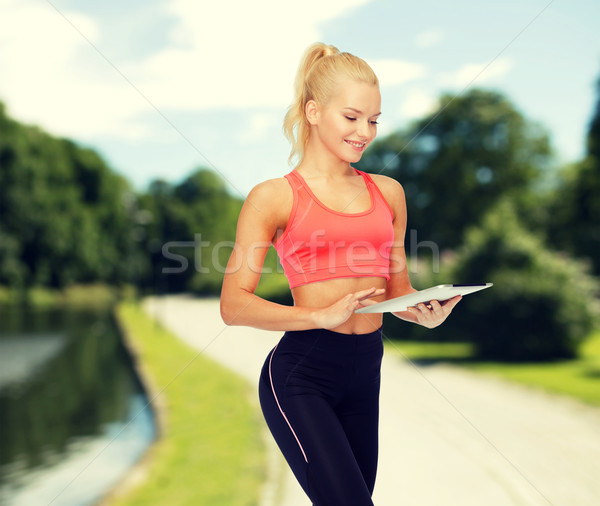 smiling sporty woman with tablet pc computer Stock photo © dolgachov