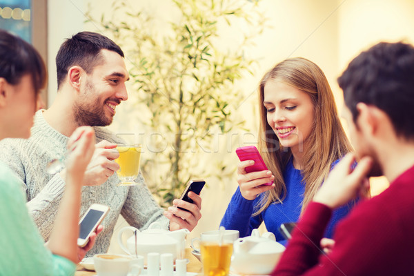 group of friends with smartphones meeting at cafe Stock photo © dolgachov