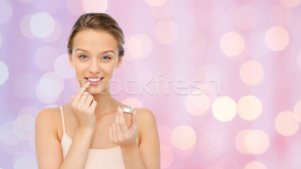 Sorridente mulher jovem lábio bálsamo lábios Foto stock © dolgachov