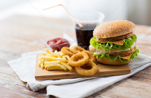 Stock photo: close up of fast food snacks and drink on table