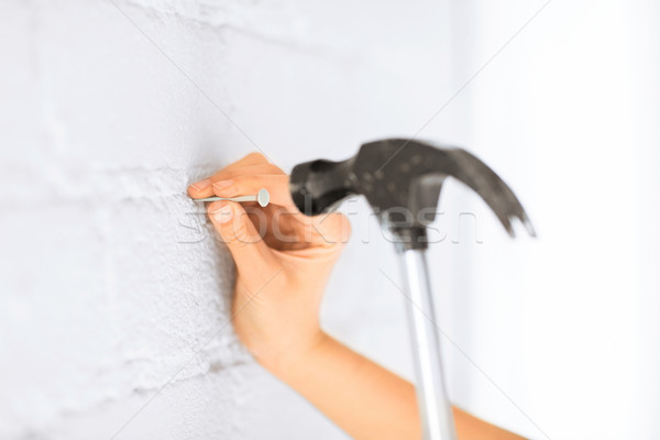 architect hammering nail in wall Stock photo © dolgachov