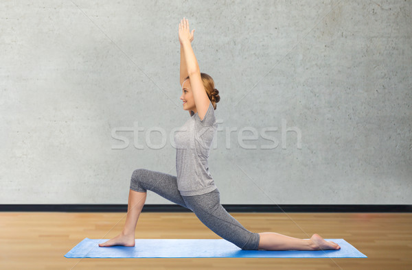 happy woman making yoga in low lunge on mat Stock photo © dolgachov