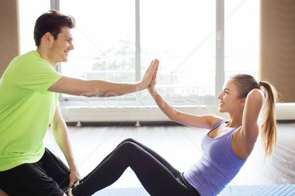 woman with personal trainer doing sit ups in gym Stock photo © dolgachov