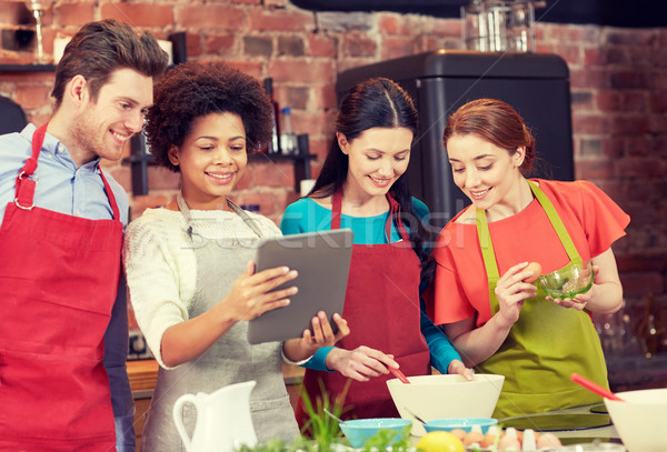 happy friends with tablet pc cooking in kitchen Stock photo © dolgachov