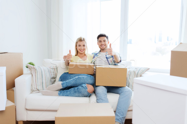 happy couple with boxes showing thumbs up at home Stock photo © dolgachov