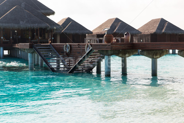 bungalow huts in sea water on exotic resort beach Stock photo © dolgachov