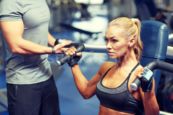 man and woman flexing muscles on gym machine Stock photo © dolgachov