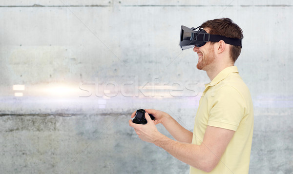 man in virtual reality headset and gamepad playing Stock photo © dolgachov