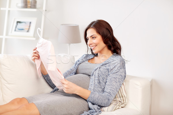 happy woman holding baby girls bodysuit at home Stock photo © dolgachov