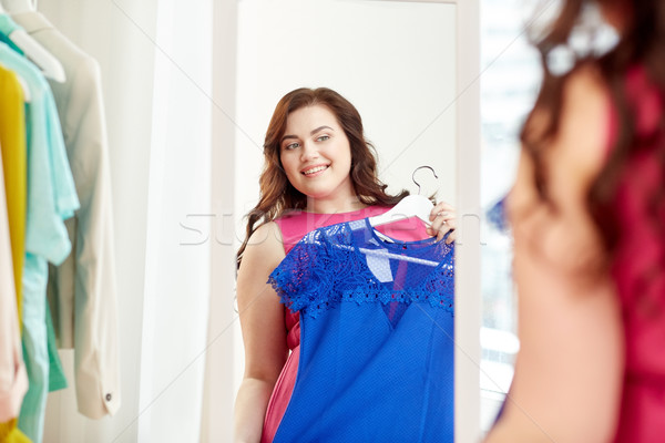 happy plus size woman with dress at mirror Stock photo © dolgachov