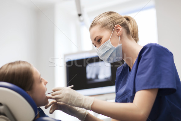 female dentist checking patient girl teeth Stock photo © dolgachov